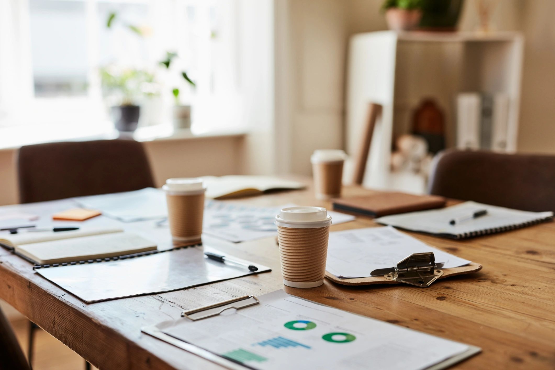 Mesa de sala de reuniones con documentos y café